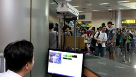 Sử dụng máy đo thân nhiệt tia hồng ngoại nhằm kiểm soát dịch bệnh ở sân bay Nội Bài. Ảnh: TTXVN