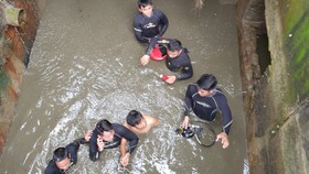 Thượng úy Trần Thành Phát cùng đồng đội đưa nạn nhân mắc kẹt  trong cống thoát nước ra ngoài 