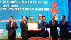 Thường trực Ban Bí thư Trần Quốc Vượng (phải)  trao Huân chương Lao động hạng hai do Chủ tịch nước  tặng Hội người Việt Nam tại Cộng hòa Czech. Ảnh: TTXVN