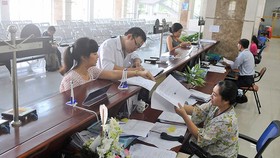 Giải quyết hồ sơ thuế cho doanh nghiệp tại Cục Thuế TPHCM. Ảnh: CAO THĂNG
