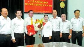 Phó Bí thư Thành ủy TPHCM Võ Thị Dung trao quyết định  và tặng hoa chúc mừng đồng chí Lê Kim Hiếu. Ảnh: CAO THĂNG