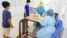 Nhân viên y tế quận Tân Bình, TPHCM lấy mẫu xét nghiệm cho người dân về từ Đà Nẵng