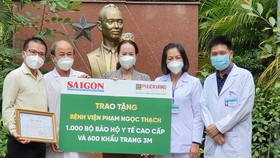 Ban Giám đốc BV Phạm Ngọc Thạch nhận bảng tượng trưng hỗ trợ từ đại diện Báo SGGP và Công ty Phúc Khang