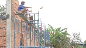 Công nhân xây nhà phổ thông tại huyện Củ Chi, TPHCM  thiếu an toàn trong lao động. Ảnh: HOÀNG HÙNG