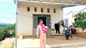 Chị Y Xuyên (xã Đắk Long, huyện Đắk Hà) bên căn nhà ở khu tái định cư