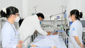 Bác sĩ Đinh Tấn Phương, Khoa Cấp cứu Bệnh viện Nhi đồng 1, TPHCM  thăm khám cho bệnh nhi trưa 10-6