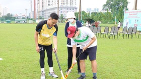 Huấn luyện viên hướng dẫn các kỹ thuật cơ bản trong bộ môn hockey cho các trẻ đặc biệt và phụ huynh. Ảnh: NGUYỄN ANH