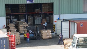 Hàng hóa tại kho vận Tân Cảng - Cát Lái đang được vận chuyển xuất nhập vào các container. Ảnh: HOÀNG HÙNG