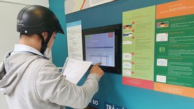 Người dân nộp hồ sơ trực tuyến tại “ATM hồ sơ” ở quận 6, TPHCM Ảnh: NGÔ BÌNH