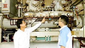 Anh Bùi Trọng Hữu trao đổi cùng công nhân trẻ về sáng kiến anh đã thực hiện. Ảnh: THÁI PHƯƠNG