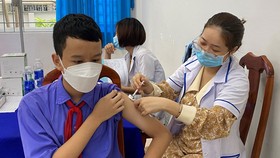 Nhân viên y tế tiêm vaccine Covid-19 cho học sinh
