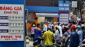 Người dân vẫn chen chúc chờ đổ xăng tại cửa hàng xăng dầu góc đường Võ Thị Sáu - Phạm Ngọc Thạch (TPHCM)  sau khi liên bộ Tài chính - Công thương  điều chỉnh giá xăng dầu chiều 11-10. Ảnh: HOÀNG HÙNG