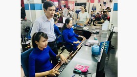 Ông Đỗ Quang Văn (đứng) kiểm tra hệ thống bán vé tại quầy vé ở Ga Sài Gòn. Ảnh: T.BA
