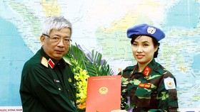 Thượng tướng Nguyễn Chí Vịnh trao Quyết định của Chủ tịch nước cho Thiếu tá Đỗ Thị Hằng Nga. Ảnh: TTXVN