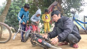 Anh Dũng sửa xe đạp cho các em học sinh ở bản Cồn