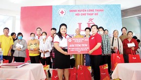 Bà Nguyễn Thu Thủy - đại diện Vedan trao bảng tượng trưng 4 căn nhà  cho đại diện Hội Chữ thập đỏ huyện Long Thành, tỉnh Đồng Nai