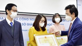 Vụ trưởng Vụ Khoa học, Công nghệ và Môi trường (Bộ GDĐT) Tạ Ngọc Đôn trao giải Nhất cho các giảng viên trẻ đoạt giải. Nguồn: Bộ Giáo dục
