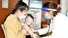 Bác sĩ Hoàng Chi Mai, phòng khám chuyên khoa Covid-19,  Bệnh viện Nhi đồng TPHCM, thăm khám cho bệnh nhi Covid-19