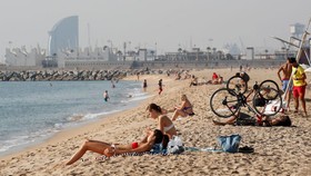 Du khách trên bãi biển ở Barcelona (Tây Ban Nha). Ảnh: Reuters