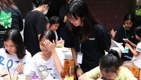 Các thành viên dự án RỪNG hướng dẫn các em nhỏ lớp học Cầu Vồng trang trí chậu và trồng cây xanh
