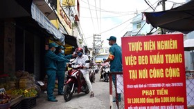 Người dân được đo thân nhiệt trước khi vào mua sắm tại chợ Nguyễn Đình Chiểu, Q.Phú Nhuận, TPHCM. Ảnh: NGỌC PHƯỢNG