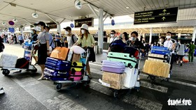 Lượng khách đến sân bay Tân Sơn Nhất vẫn rất đông trong ngày đầu tiên cả nước quay lại làm việc sau kỳ nghỉ Tết kéo dài - Ảnh: TỰ TRUNG