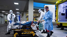 Nhân viên y tế chuyển bệnh nhân nhiễm COVID-19 lên xe cứu thương tới bệnh viện ở Ulm, tây nam nước Đức, ngày 29/3. Ảnh: AFP/TTXVN