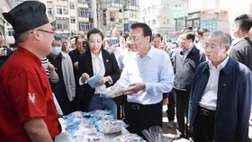 Thủ tướng Lý Khắc Cường ghé thăm một quầy bán hàng rong. (Ảnh: THX)