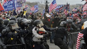 Cảnh sát chặn người biểu tình cố gắng vượt qua hàng rào an ninh để xâm nhập tòa nhà Quốc hội Mỹ ở Washington, DC ngày 6/1/2021. Ảnh: AFP/TTXVN