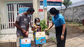 Representative of the Kiên Giang Labour Federation give food to poor residents in Bình An Commune, Châu Thành District. — VNA/VNS Photo Lê Huy Hải