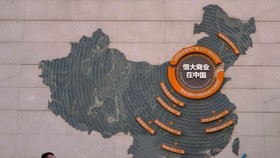 Một người đứng gần tấm bản đồ các dự án phát triển của Evergrande trên bức tường ở quảng trường thành phố ở Bắc Kinh, ngày 21 tháng 9. (Ảnh AP)