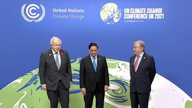 Vietnamese Prime Minister Phạm Minh Chính is welcomed by UK Prime Minister Boris Johnson (left) and UN Secretary-General António Guterres, at the opening of the UN climate summit in Glasgow, Scotland, yesterday. — VNA/VNS Photo