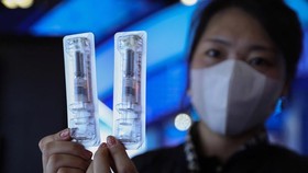Một nhân viên công ty Walvax đang cầm vaccine Covid-19 của công ty - Ảnh: Getty Images