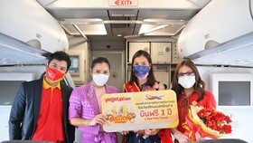 Tourism Authority of Thailand’s representative (2nd from the left) congratulates the 10 millionth passenger on Thai Vietjet’s special flight  