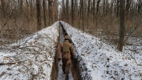 Một quân nhân Ukraine đi dọc các vị trí chiến đấu trên đường liên lạc với phiến quân ly khai do Nga hậu thuẫn gần thị trấn Avdiivka ở Vùng Donetsk, Ukraine, vào ngày 13 tháng 2 năm 2021. (Oleksandr Klymenko / Reuters)