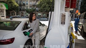 Khách hàng bơm xăng tại một trạm xăng ở New York, Mỹ, ngày 10/6/2022. Ảnh: THX/TTXVN