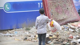 Vô tư vứt rác vào một bãi rác tự phát   Ảnh: THÀNH TRÍ