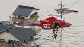 Sơ tán các nạn nhân bị mắc kẹt tại các khu vực ngập lụt nghiêm trọng ở Kurashiki, tỉnh Okayama ngày 7-7 vừa qua. (Ảnh: Kyodo/TTXVN)