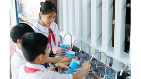  Các em học sinh Trường Tiểu học Hưng Mỹ 2, huyện Mỏ Cày, tỉnh Bến Tre uống nguồn nước sạch.