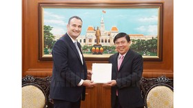 Chủ tịch UBND TPHCM Nguyễn Thành Phong tặng quà lưu niệm cho tân Tổng lãnh sự Canada Kyle Nunas. Ảnh: hcmcpv