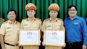 Đại diện Thành đoàn TNCS TPHCM đã trao bằng khen tuyên dương nghĩa cử đẹp của thượng úy Vũ Đình Nam và trung úy Đoàn Tấn Phú. Ảnh: THÁI PHƯƠNG