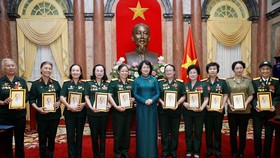 Phó Chủ tịch nước Đặng Thị Ngọc Thịnh tặng chân dung Chủ tịch Hồ Chí Minh cho các đại biểu nữ bộ đội Trường Sơn, thanh niên xung phong, dân quân hỏa tuyến, công nhân giao thông thời kỳ kháng chiến. Ảnh: TTXVN