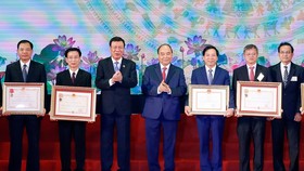 Thủ tướng Nguyễn Xuân Phúc trao tặng Huân chương Độc lập hạng Ba và Huân chương Lao động hạng Nhất cho các tập thể.  Ảnh: TTXVN
