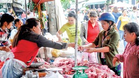 Người tiêu dùng chọn mua thịt heo tại một chợ ở TPHCM. Ảnh: ĐỨC THIỆN