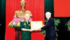 Tổng Bí thư, Chủ tịch nước Nguyễn Phú Trọng, Bí thư Quân ủy Trung ương, trao Huy hiệu 70 năm tuổi Đảng tặng đồng chí Lê Khả Phiêu ngày 25-8-2019. Ảnh: TTXVN