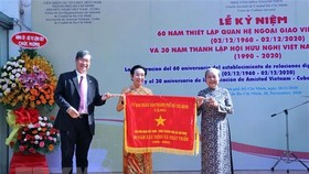Ông Vương Đức Hoàng Quân, Chủ tịch Liên hiệp các tổ chức hữu nghị TPHCM, trao Cờ truyền thống của UBND TP tặng Hội hữu nghị Việt Nam-Cuba TPHCM. Ảnh: TTXVN