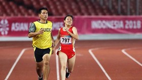 HLV Nguyễn Văn Phương (trái) dẫn VĐV điền kinh khuyết tật Việt Nam thi đấu ở Asian Paragames 2018. Ảnh: P.NGUYỄN