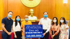 Bác sĩ Trần Quốc Khánh cùng đại diện của Thái Hà Books trao tặng số tiền 160 triệu đồng từ chương trình đấu giá sách ủng hộ Quỹ vaccine phòng Covid-19
