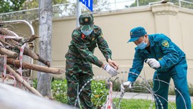 Lực lượng chức năng tháo dỡ chốt kiểm soát tại ngã 4 đường Nguyễn Thị Minh Khai - Hai Bà Trưng, quận 1. Ảnh: DŨNG PHƯƠNG