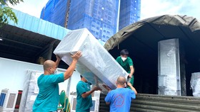Nhân viên y tế Trung tâm Hồi sức Covid-19 do BV Bạch Mai quản lý đang vận chuyển đồ đạc trở về Hà Nội